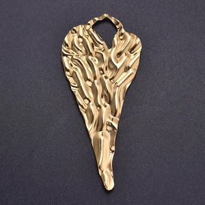Gros plan détaillé du pendentif coeur en acier doré avec texture froissée unique