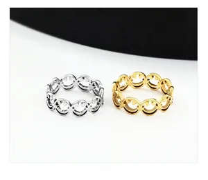 Detailed view of silver and gold stainless steel rings with laser-cut smiley face pattern