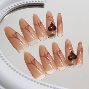 Long almond press-on nails with marble patterns and red 3D heart-shaped jewels