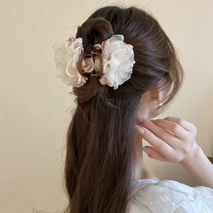 Pince à cheveux avec fleurs en dentelle et perles vue de côté sur un chignon élégant