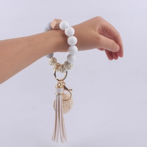 Detailed close-up of MAMA engraved wooden tag and white tassel on silicone beaded keychain