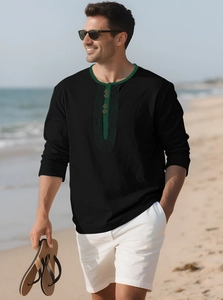 Detailed close-up of a black linen shirt with green trim and wooden buttons on beach