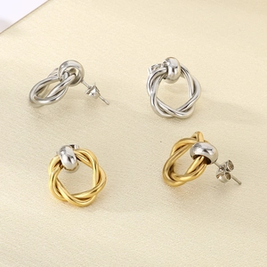 Close-up of stylish twisted metal hoop earrings in gold and silver finishes