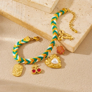 Colorful woven rope bracelet with pearl heart, cherry charm, and golden bow pendant