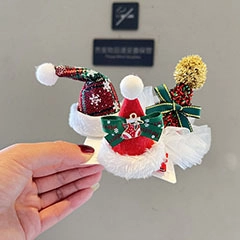 Macro shot of glittery Christmas tree and Santa hat hair clips with festive bow accents