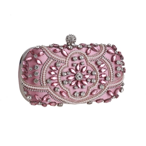 Close-up of pink evening clutch bag with exquisite pearls and sparkling rhinestones
