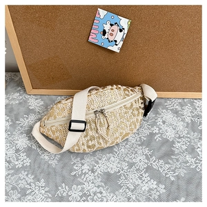Detailed macro view of beige woven straw waist bag texture with zipper and buckle strap