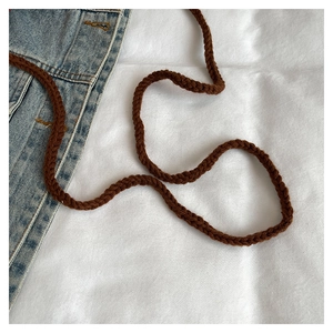 Nahaufnahme des tiefbraunen Webriemens mit feiner Textur für die gestrickte Umhängetasche