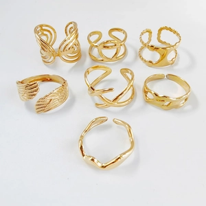 Detailed set of golden stainless steel open rings with geometric and wing patterns