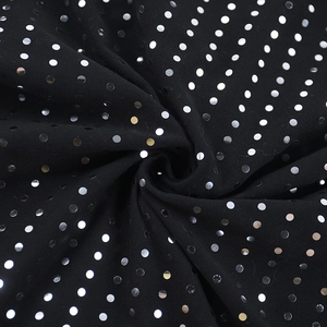 Gros plan sur tissu noir avec sequins argentés brillants et détails de drapé élégant