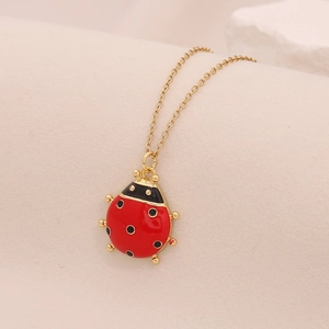 Dettaglio macro della collana con ciondolo a coccinella in smalto rosso e zirconi