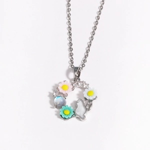 Détail du collier couronne florale argentée avec fleurs roses, lapin blanc et pendentif pierre de lune