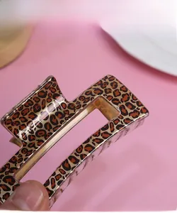 Close-up of leopard print hair claw clip showing glossy finish and hollow design