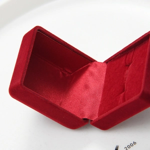 Macro view of opened red velvet jewelry box with satin lining and ring slots