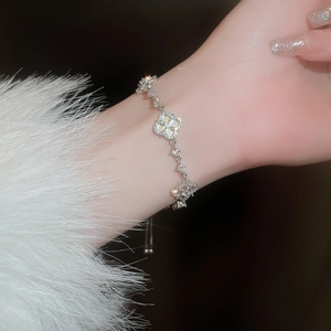 Detail view of silver clover bracelet with mother of pearl and zircon stones on wrist