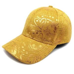 Close-up of golden baseball cap with metallic heart prints and Love You embroidery