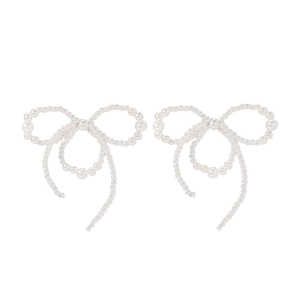 Detailed view of white pearls arranged in a bow shape on elegant earrings