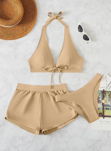 Three-piece striped khaki bikini set with halter top and high-waisted shorts on marble