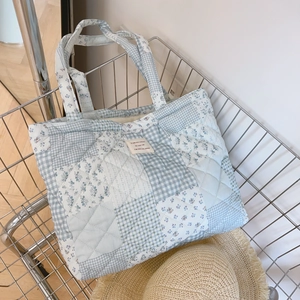Quilted floral cotton tote bag with light blue checkered patterns in a metal cart