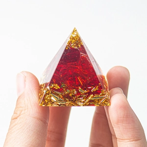 Handheld view showing detail of 3cm crystal pyramid with red stones and gold foil flakes