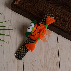 Detail of sequined pumpkin slap bracelet with plush orange texture and bow for Halloween