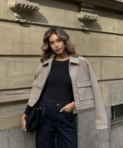 Detailansicht der hellbraunen Tweedjacke mit großen Taschen und Metallreißverschluss