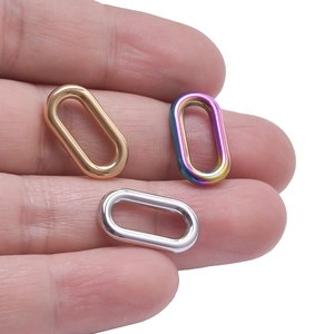 Oval stainless steel necklace rings in gold, silver and rainbow plating on finger