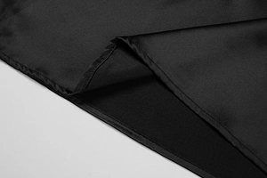 Close-up of black satin dress fabric showing premium stitching and soft glossy texture