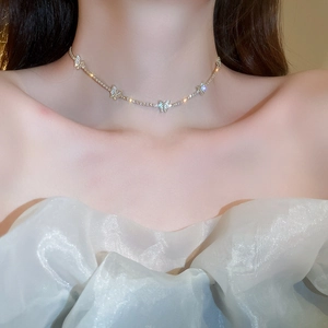 Detailed view of silver butterfly necklace with sparkling crystals on model neckline
