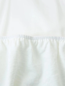 Détail du tissu blanc plissé élastique avec une technique de smocks professionnelle