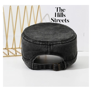 Detail of black washed denim military cap featuring a bronze adjustable metal buckle back