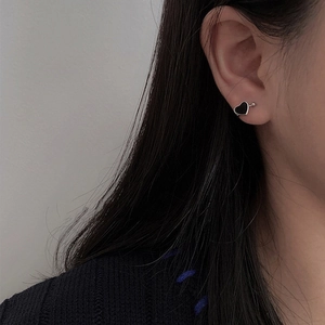 Minimalist black heart ear clip on female model with silver base and cool aesthetic