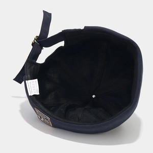 Detail of navy blue cotton docker hat featuring adjustable buckle and 100% cotton lining