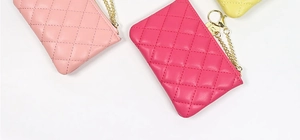 Detail of quilted leather coin purses in pink and rose with gold chain and metal hardware