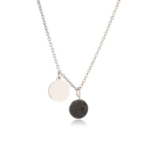 Detailed close-up of a silver metal disc and black lava stone pendant on a curb chain