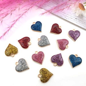 Gros plan de pendentifs en forme de cœur en émail pailleté pour bijoux DIY