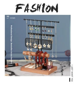 Detail view of multi-tier black metal jewelry organizer with a wooden base and hooks