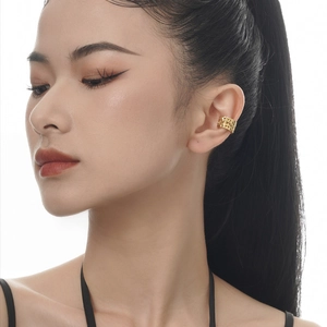 Minimalist gold ear cuff with textured woven pattern worn by a female model