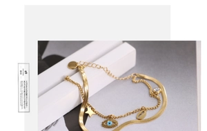 Macro shot of gold-plated double-layer bracelet with evil eye star and crystal charms