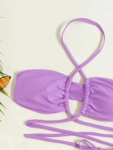 Close-up of purple bikini top with drawstring ruched detail and cross tie straps