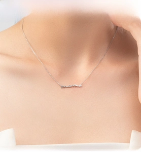 Macro shot of a silver S925 sterling silver chain with a cursive mama script pendant