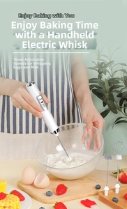 Detail of handheld electric whisk beating cream in a glass bowl with three stir heads
