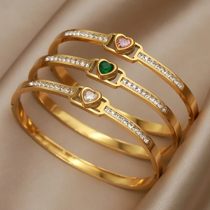 Titanium steel heart bangles with pink, green, and clear gems on champagne silk