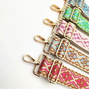 Detailed view of bohemian style woven bag straps with gold metal lobster clasps