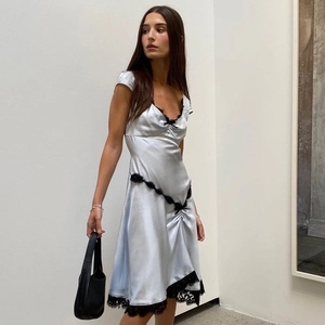 Dettaglio di abito in raso azzurro con finiture in pizzo nero e trama effetto seta