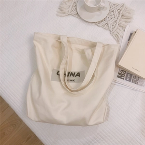 Détail du grand sac cabas en toile kaki avec impression China Be Back et texture