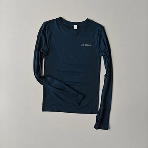 Detail of dark blue long sleeve yoga top featuring thumbholes and ribbed compression texture