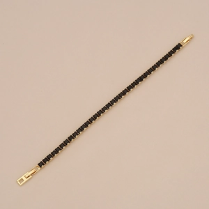Détail du bracelet tennis doré avec zircons noirs carrés et fermoir à charnière