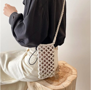 Close-up of bohemian hand-woven cotton phone bag with textured mesh detail