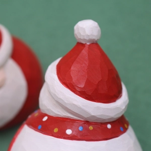 Macro detail of Santa figurine featuring a textured red hat and white pompom accent